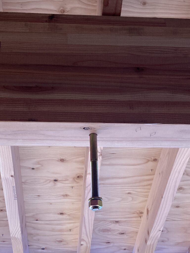 梁の上から下まで穴を開け、座金が上になるように座付ボルトを挿しています。